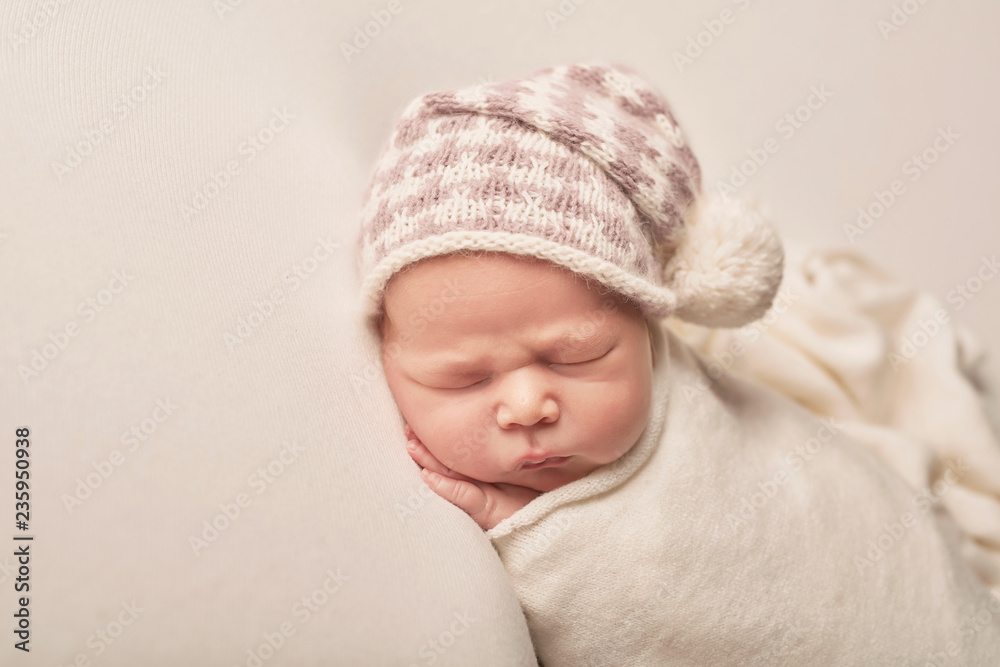Cute newborn little boy sleeping on light background. Baby goods packaging template. Closeup portrait of newborn baby with smile on face. Healthy and medical concept. Eco conception. Nursery. Cute newborn little boy sleeping on light background. Baby goods packaging template. Closeup portrait of newborn baby with smile on face. Healthy and medical concept. Eco conception. Nursery.