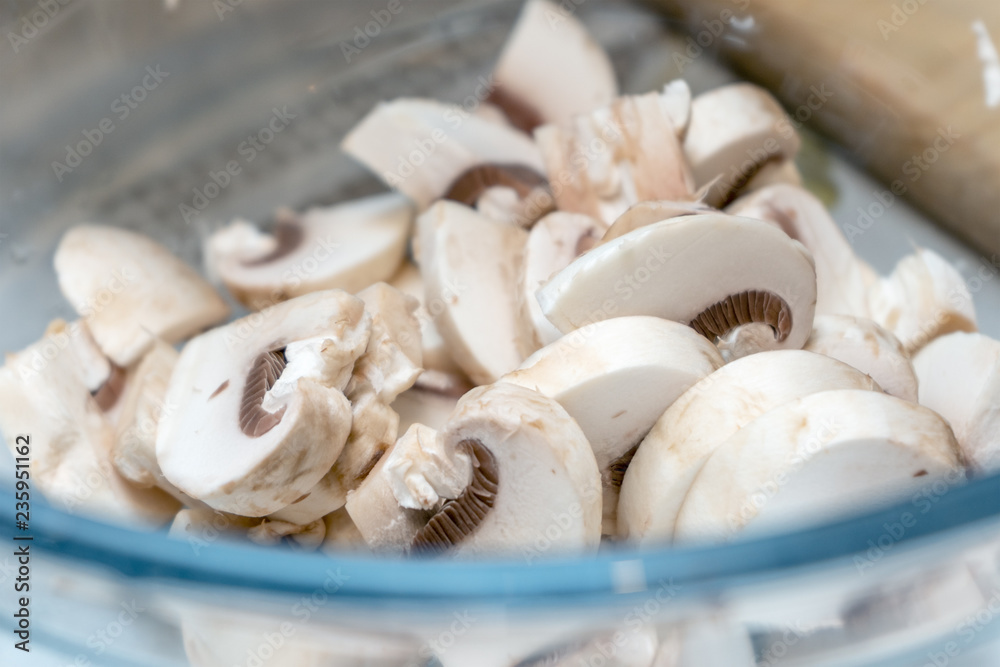 Sliced mushrooms are in a dish Sliced mushrooms are in a dish