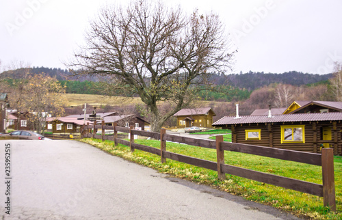 Road, wooden fence, wooden home lawn countryside in autumn © natka80