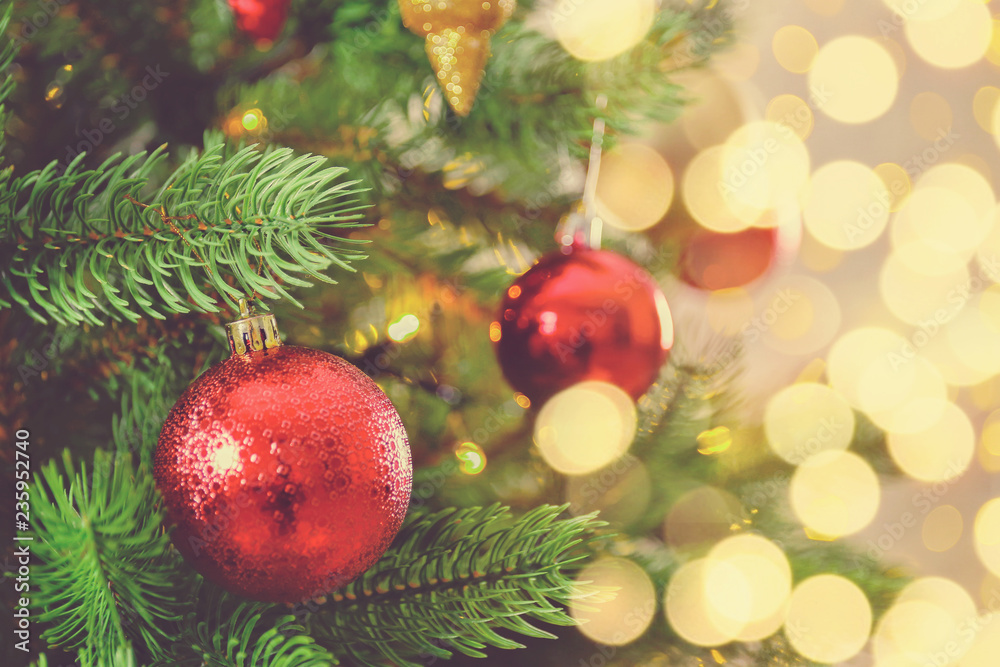 Decorated Christmas tree on soft yellow lights with bokeh effect background. Festive composition with fir and blurry sparkling backdrop, new year holiday decorations. Close up, copy space. Decorated Christmas tree on soft yellow lights with bokeh effect background. Festive composition with fir and blurry sparkling backdrop, new year holiday decorations. Close up, copy space.