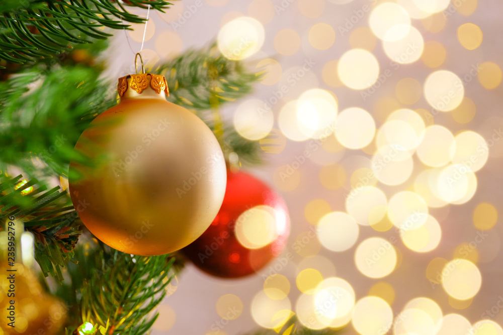 Decorated Christmas tree on soft yellow lights with bokeh effect background. Festive composition with fir and blurry sparkling backdrop, new year holiday decorations. Close up, copy space. Decorated Christmas tree on soft yellow lights with bokeh effect background. Festive composition with fir and blurry sparkling backdrop, new year holiday decorations. Close up, copy space.