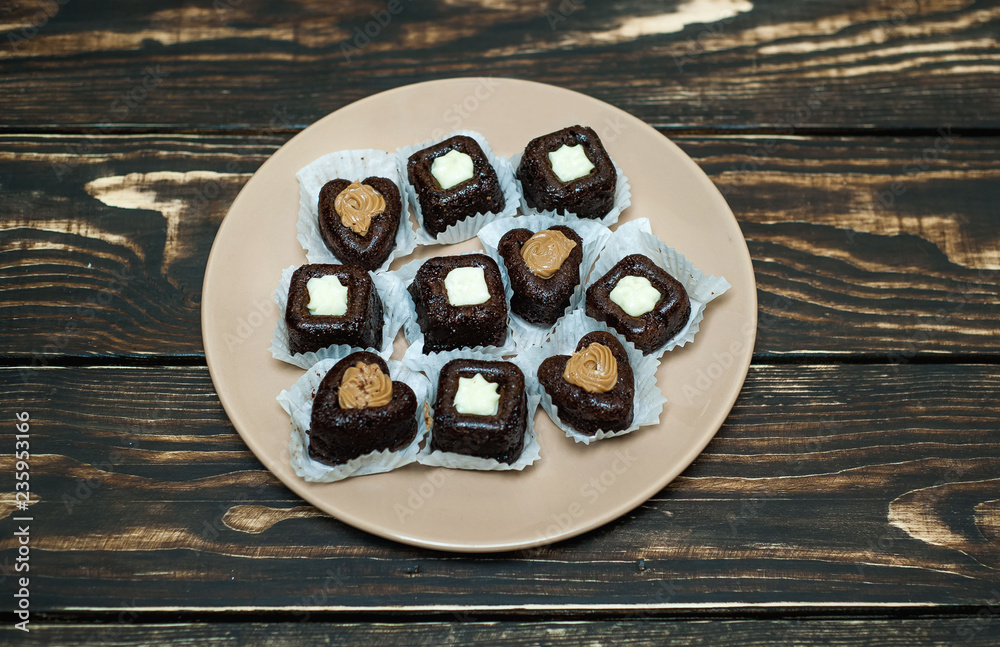 cupcakes with hearts in a plate on a wooden background cupcakes with hearts in a plate on a wooden background