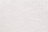 Abstract knitted background. White woolen sweater texture. Close up picture of knitted pattern.