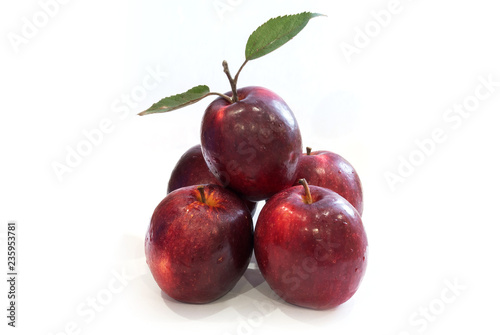 Fresh red apples with leaves isolated on white background