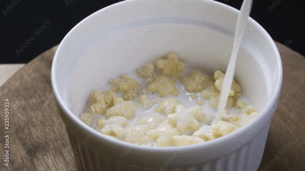 Bowl with healthy cornflakes and milk on light table, closeup Bowl with healthy cornflakes and milk on light table, closeup