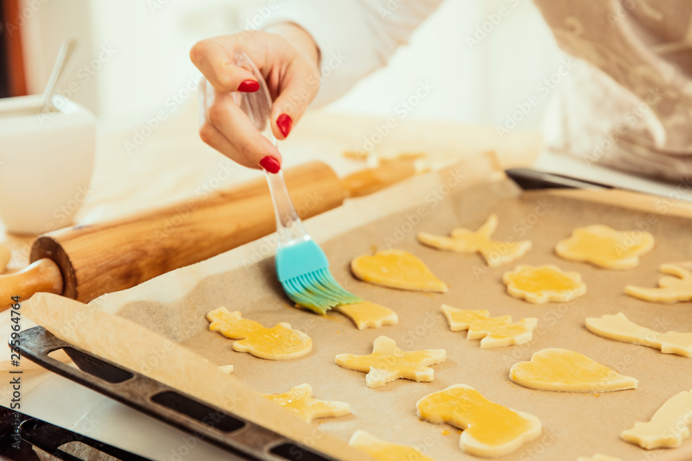 Woman's hand smears beaten egg on homemade cookies Woman's hand smears beaten egg on homemade cookies