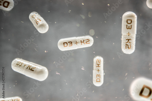 Pills float in the air with inscription D3 + K2 vitamins