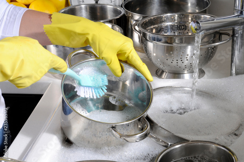 WASHING POTS AND PANS WEARING RUBBER GLOVES