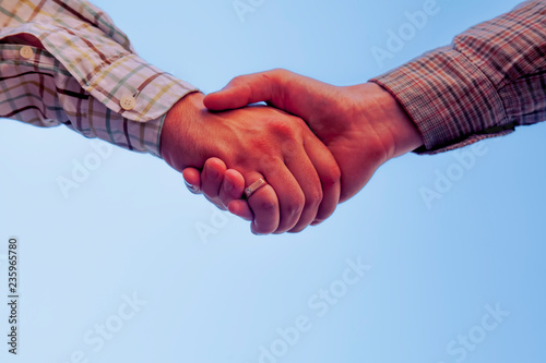 Handshake of two man as symbol agreement on establishing friendship and cooperation.