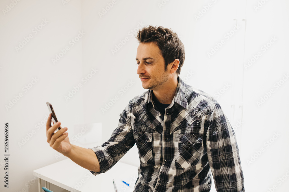 Smiling young man taking selfie on smartphone Smiling young man taking selfie on smartphone