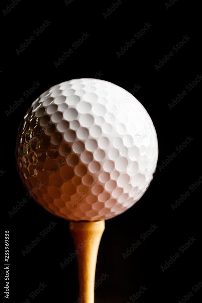 Close Up of Golf Ball on Tee, Isolated on Black Background Close Up of Golf Ball on Tee, Isolated on Black Background