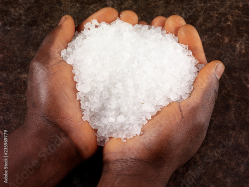 MAN HOLDING ROCK SALT GRANULES