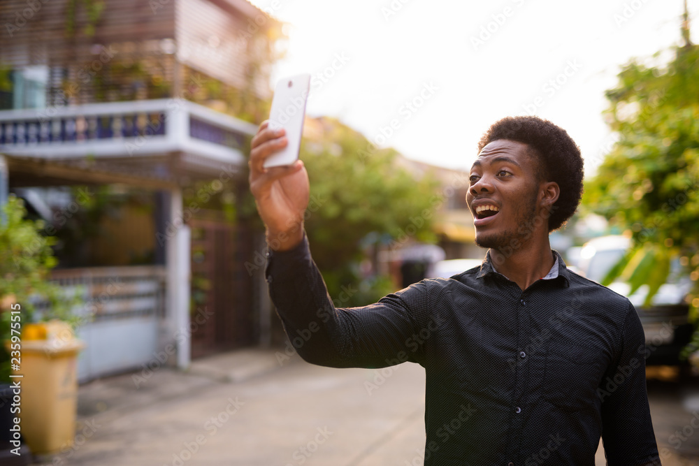 Young handsome African man using mobile phone outdoors Young handsome African man using mobile phone outdoors
