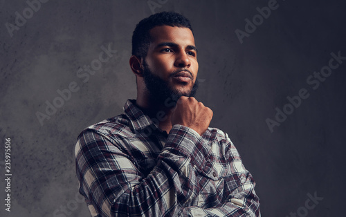 Portrait of a pensive African-American guy with a beard wearing a checkered shirt photo