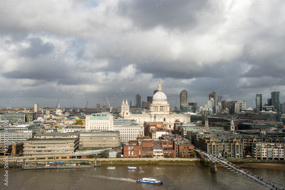 Scenic overcast view of the city skyline with a patch of sun lighting St Paul’s Cathedral above the River Thames in London, England