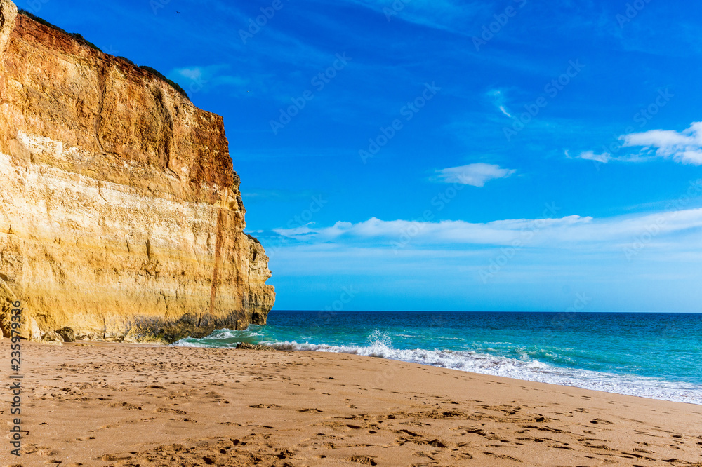 Sunny beach with cliff, sea and blue sky. Benagil Beach, Portugal, popular travel and holiday destination in Europe