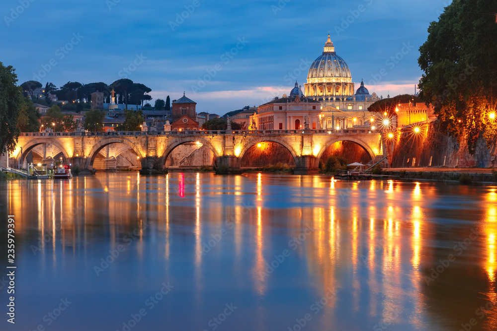 Saint Peter Cathedral and Saint Angel bridge over the Tiber River during morning blue hour in Rome, Italy.