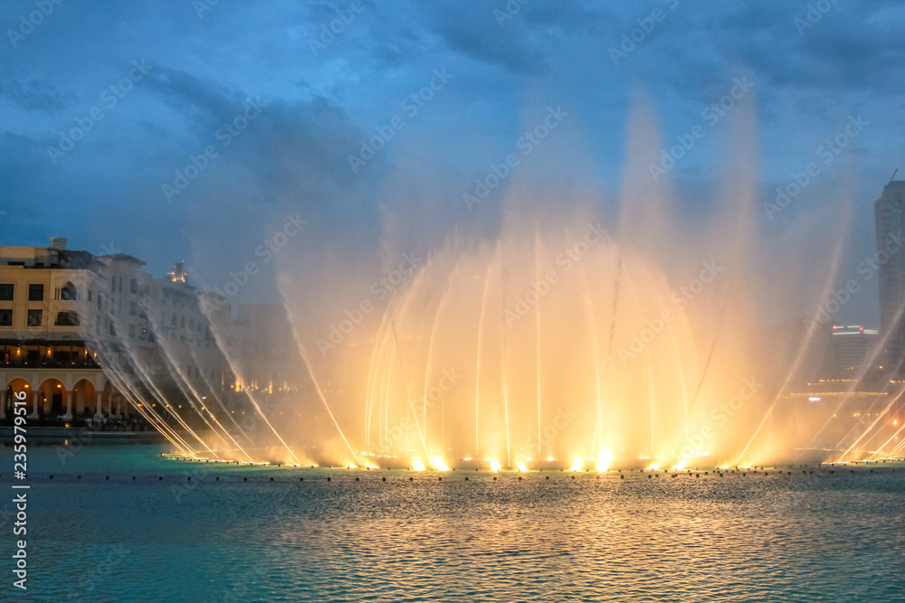 Fototapeta premium Nocny widok pokazu świateł w tańczącej fontannie w Dubaju. Dubajska fontanna, największa na świecie fontanna z choreografią na obszarze jeziora Burj Khalifa, gra w rytm wybranej muzyki.