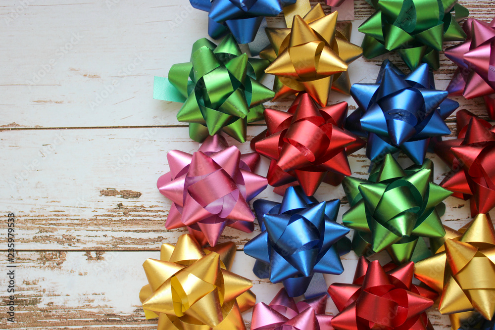 Festive bows on a background of white boards close-up. The concept of celebrating a birthday, new year and Christmas. Copy space. Festive bows on a background of white boards close-up. The concept of celebrating a birthday, new year and Christmas. Copy space.