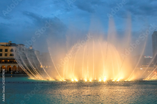 Night view of the light show at Dubai Dancing Fountain. The Dubai Fountain, the world largest choreographed fountain on Burj Khalifa Lake area, performs to the beat of the selected music.
