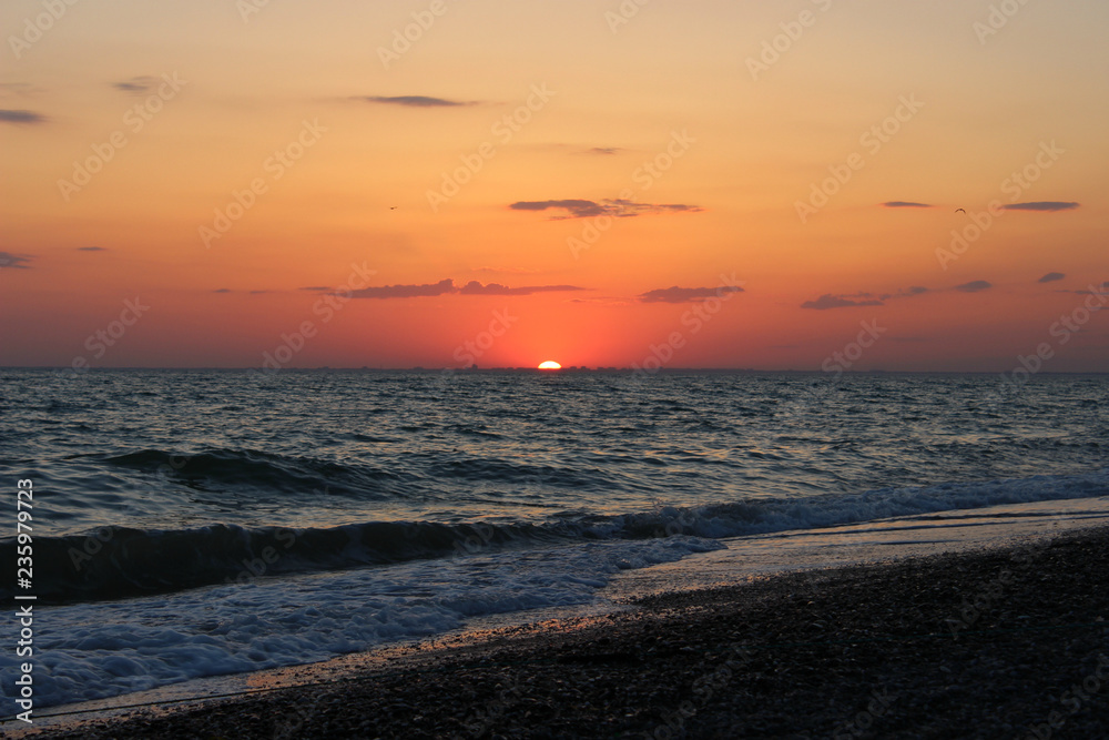 Seascape as a background, beautiful sunset over the sea, pebble beach, vacation, vacation.