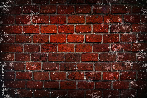 Abstract Christmas background. Red brick wall close-up, texture, background, grunge. White snowflakes on brick wall background. Vignette, copy space