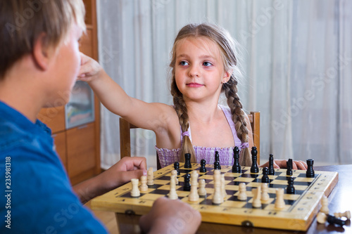 children at chess board indoors
