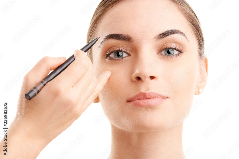 Woman applying makeup against white background, Studio beauty shot