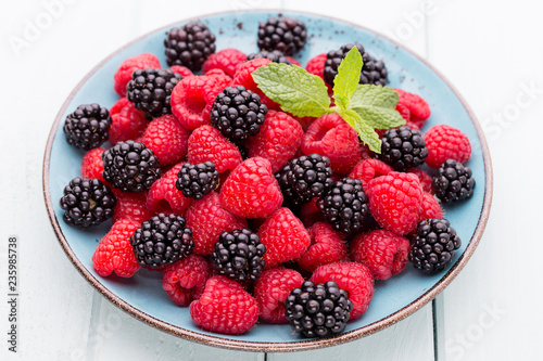 Fresh raspberries in a plate on a  vintage background.