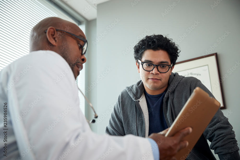 Fototapeta premium Doctor talking to boy in examination room