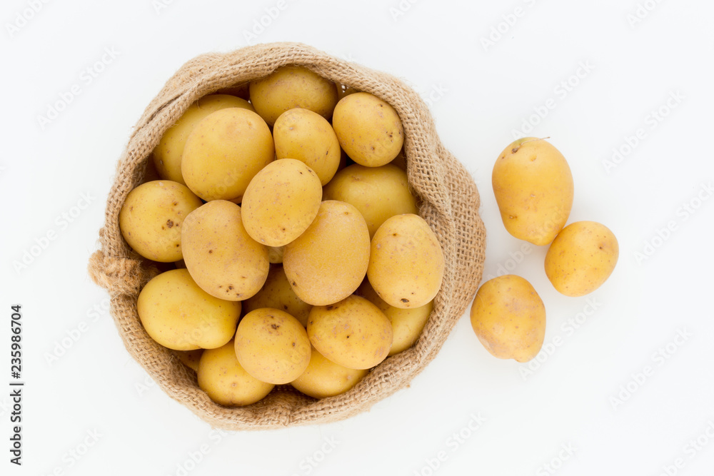 Sack of fresh raw potatoes on wooden background, top view Sack of fresh raw potatoes on wooden background, top view