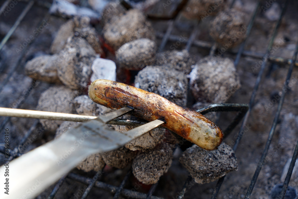 Open fire in the grill to grill a sausage with a charcoal barbecue in the garden Open fire in the grill to grill a sausage with a charcoal barbecue in the garden