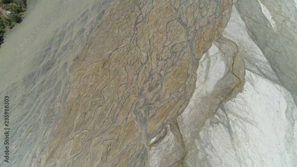 Fototapeta premium Parched river in mountain province Luzon, Philippines. Aerial view Drought in mountain valley, dry and shallow Bucao river.