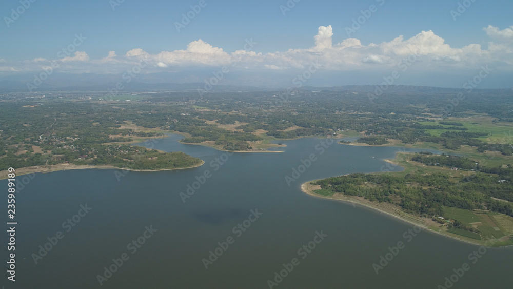 Aerial view of Paoay lake against background of mountains and sky with clouds. Paoay Lake National Park, Ilocos Norte, Philippines.