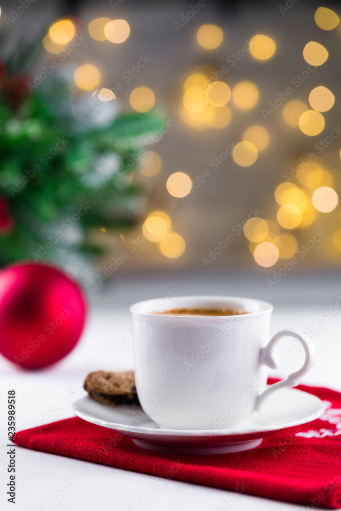 Cup of espresso or americano coffee in white cup in cozy Christmas arrangement, festive decoration with bokeh background, copy space Cup of espresso or americano coffee in white cup in cozy Christmas arrangement, festive decoration with bokeh background, copy space