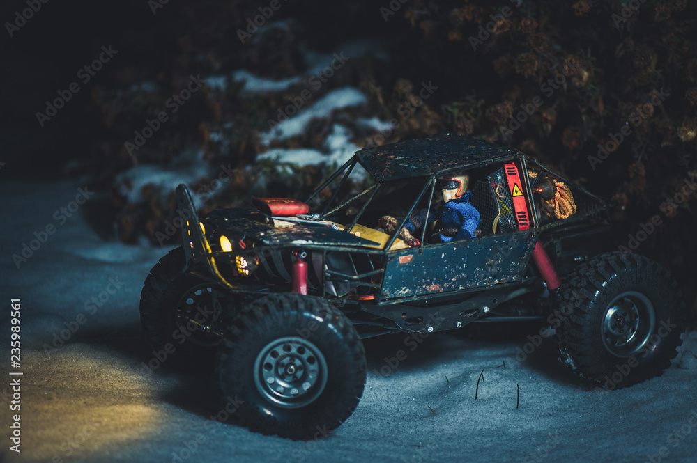 Fototapeta premium radio-controlled car in the snow at night, lights shine. Christmas present rc car