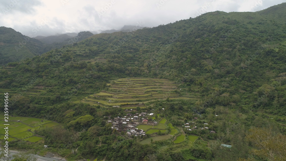 Aerial view of rice fields and agricultural land on the slopes of the mountains. Mountains covered forest, trees. Cordillera region. Luzon, Philippines.