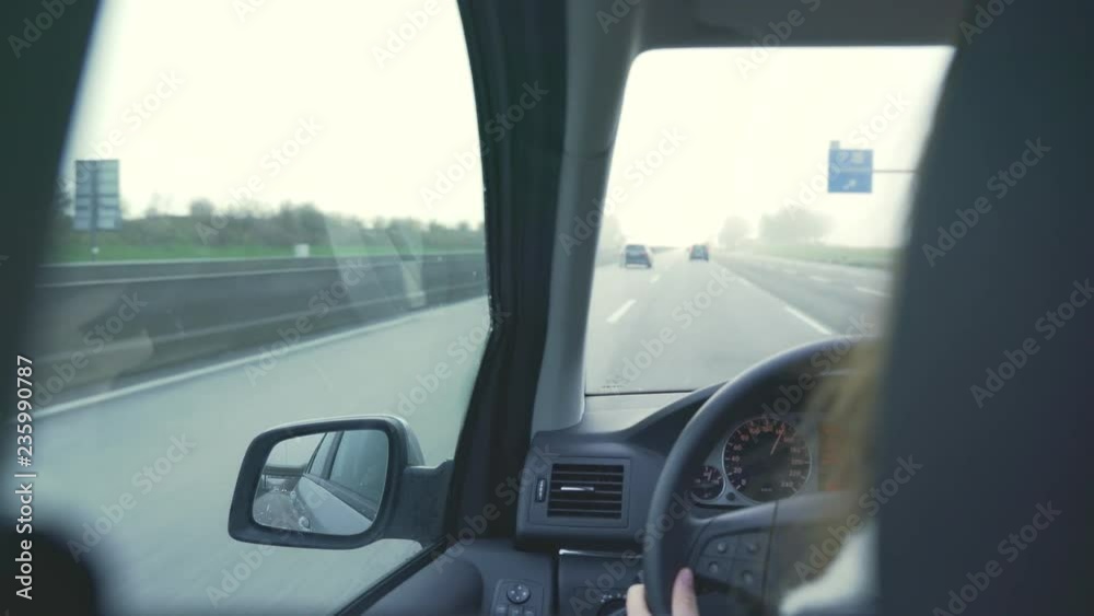 female hands on the steering wheel while the car is moving. Woman behind the wheel. Drives over German highway