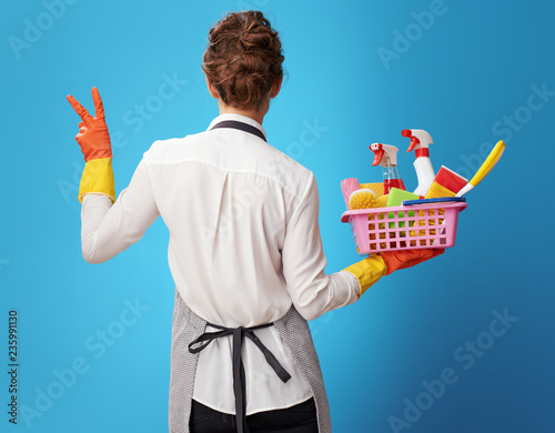 scrubwoman with a basket with detergents and brushes showing vic photo