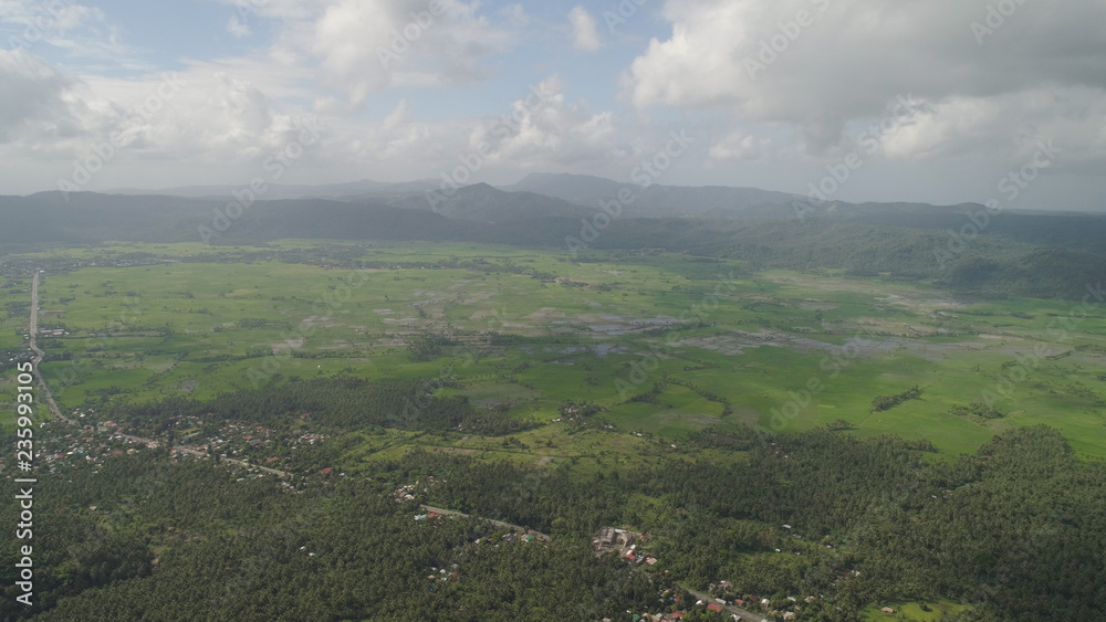 Obraz premium Mountain valley with river, farmland, rice fields. Aerial view of Mountains with green tropical rainforest, trees, jungle with sky. Philippines, Luzon.