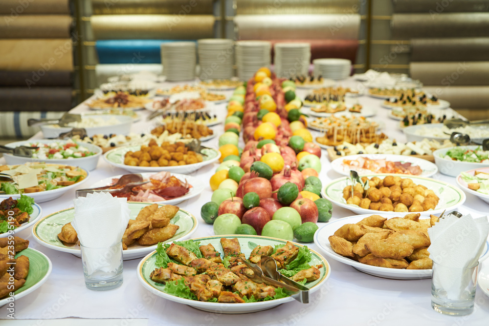 Catering table set service with cold snacks, canapes, fruits and Catering table set service with cold snacks, canapes, fruits and