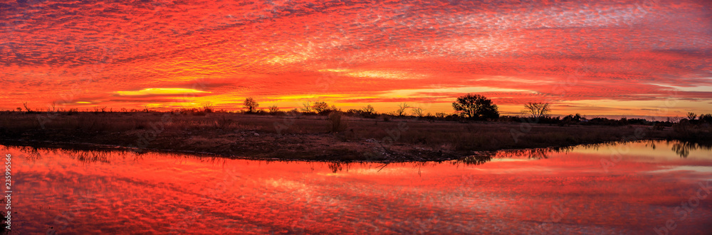 Naklejka premium Orange yellow sunrise panorama over water