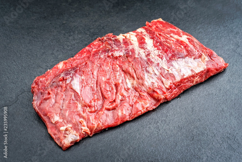 Raw wagyu bavette de flanchet steak offered as top view on a black board photo
