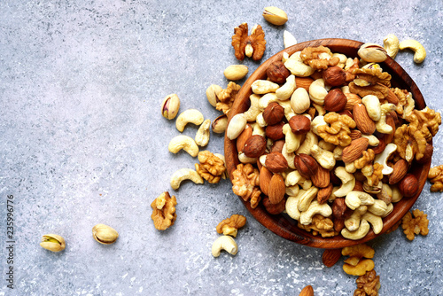 Wooden bowl with nuts ( pistachio, walnut, hazelnut, cashew, almond) .Top view with copy space.