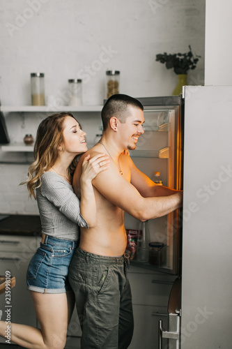  beautiful couple in the kitchen take food out of the fridge