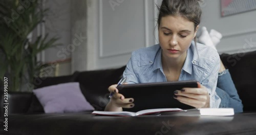 Young woman using digital tablet computer in home photo