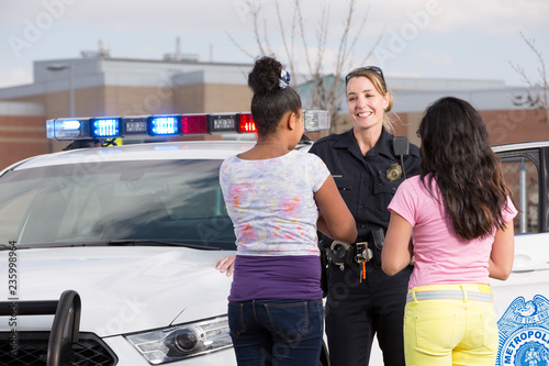 Policewoman talking to two young girls photo