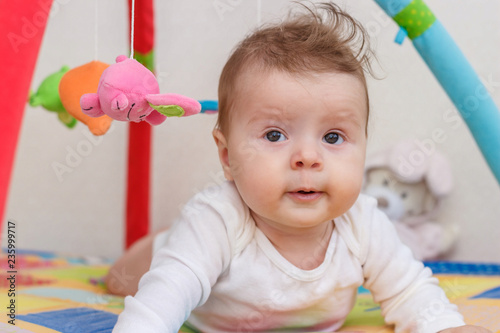 Little child on the colored mat for developing