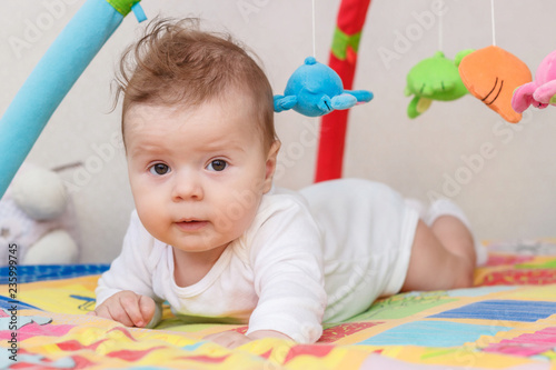 Little child on the colored mat for developing