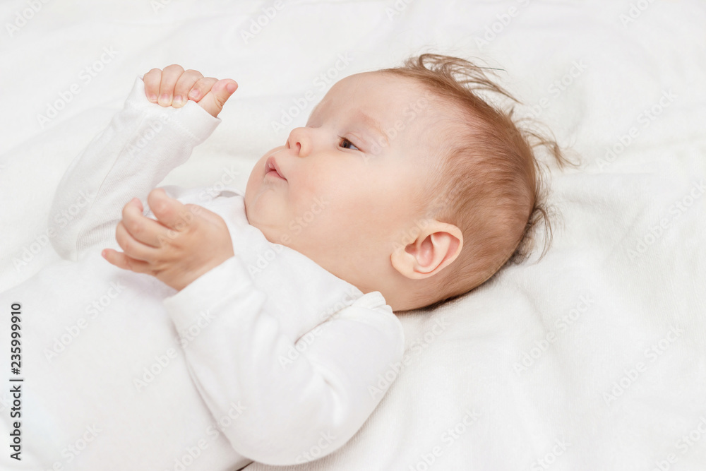 Happy child on the white blanket, top view Happy child on the white blanket, top view